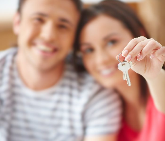 Hand of young woman showing key from new flat